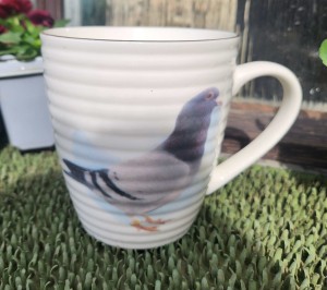 Kubek z charakterystycznymi prążkami i motywem gołębia 